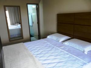 A bed or beds in a room at Pousada Calugi