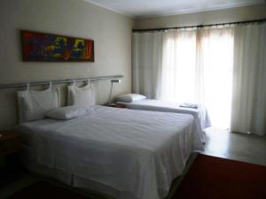 Giường trong phòng chung tại Pousada Calugi