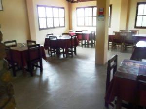 un comedor con mesas y sillas en un restaurante en Pousada Calugi, en Triunfo