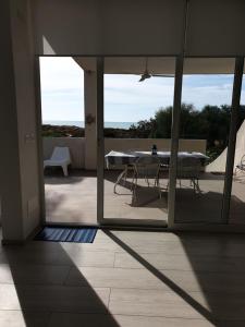 Elle offre une vue sur une terrasse avec une table et des chaises. dans l'établissement Terrazza Anticaglie, à Punta Braccetto