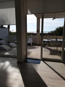 Elle offre une vue sur une terrasse avec une table et des chaises. dans l'établissement Terrazza Anticaglie, à Punta Braccetto