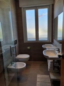 łazienka z 3 umywalkami i 2 toaletami w obiekcie Hotel Esplanade w Cesenatico