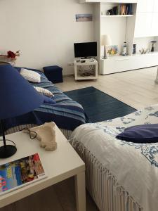 蓬塔巴拉切托的住宿－Terrazza Anticaglie，客房设有两张床、一张桌子和一台电视机。