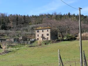 an old house on a hill in a field at I Castagnini in Montecatini Val di Cecina