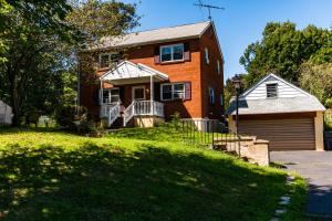 a brick house with a porch and a garage at Red brick house in Chalfont