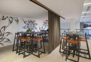 un comedor con mesas y sillas y una pared con flores en Global Luxury Suites in South End, en Boston