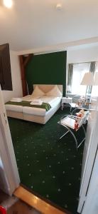 a bedroom with a bed and a green wall at Hotel Deutsches Haus in Heiligenhafen