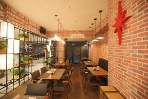 a restaurant with wooden tables and a brick wall at eSuítes Congonhas by Atlantica in São Paulo