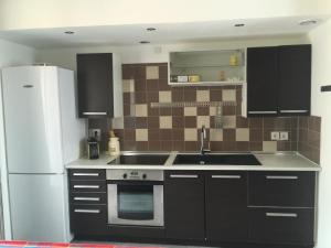 a kitchen with a sink and a refrigerator at Le Petit Nid Cosy in Esnandes