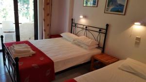 a bedroom with two beds and a red stool at Villa Makis in Vasiliki