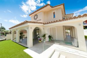a villa with a lawn in front of it at Suimi's Hotel in Villasimius