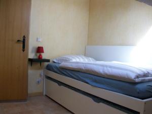 a bedroom with a bed with a blue blanket at Eifel Lodge in Butgenbach