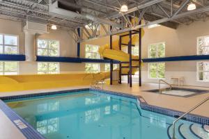 a swimming pool with a slide in a building at Microtel Inn & Suites by Wyndham Portage La Prairie in Portage La Prairie