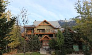 uma grande casa de madeira no meio de uma floresta em Glacier's Reach by Whistler Retreats em Whistler