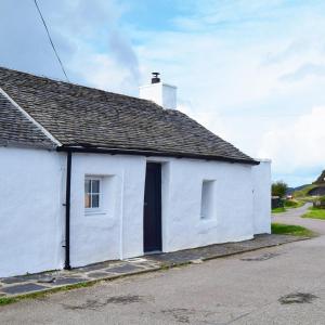 una casa bianca con una porta nera su una strada di Number 10 a Cullipool