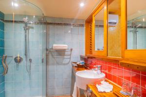 a bathroom with a shower, sink, and toilet at Sanctuary Rarotonga on the Beach (Adults Only) in Rarotonga