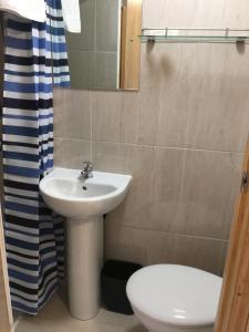 een badkamer met een wastafel, een toilet en een spiegel bij 15 New Row in Londen