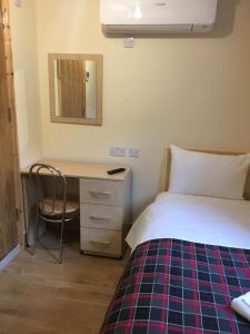 een slaapkamer met een bed en een bureau met een spiegel bij 15 New Row in Londen