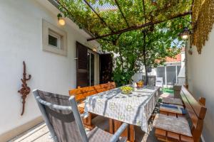a table and chairs on a patio with a pergola at Holiday Home Tamjan in Supetar