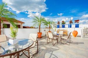 a patio with a glass table and chairs and palm trees at Araçatuba Plaza Hotel in Araçatuba