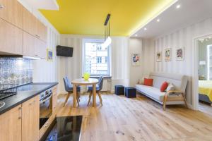 a kitchen and living room with a table and a couch at Apartament przy Parku Krakowskim in Kraków