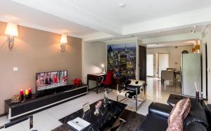 a living room with a couch and a tv at Red Mango Hotel and Apartments in Sekondi-Takoradi