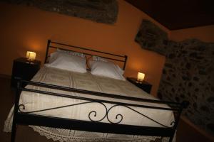 a bedroom with a bed with white pillows and two lamps at Casa Do Quelho in Janeiro de Cima