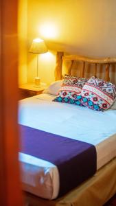 1 cama con 2 almohadas en una habitación en Posada Los Tajibos en Puerto Iguazú