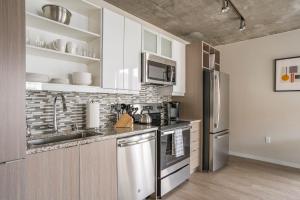 a kitchen with stainless steel appliances and white cabinets at Mint House Minneapolis - Downtown West in Minneapolis