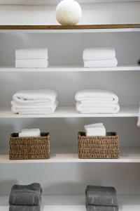 a bathroom shelf with towels and baskets on it at Cottage de Vinck in Ieper