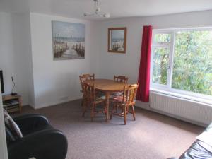 a dining room with a table and chairs and a window at The Bungalow Lymington 1 mile from New Forest in Lymington