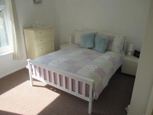 a bedroom with a white bed and a window at The Bungalow in Lymington