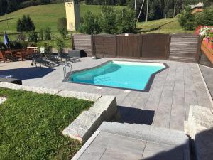 - une piscine dans une cour avec une terrasse dans l'établissement Pension Altvogtshof, à Eisenbach