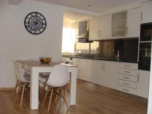 a kitchen with white cabinets and a table and chairs at Casa do Largo in Faro