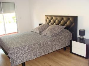 a bedroom with a large bed with a brown headboard at Casa do Largo in Faro