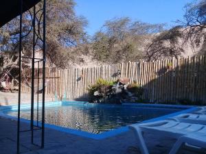 a swimming pool in front of a wooden fence at Hospedaje Rocha in Ica