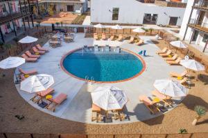 an overhead view of a swimming pool with chairs and umbrellas at Texican Court, by Valencia Hotel Collection in Irving