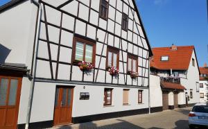 un bâtiment noir et blanc avec des boîtes de fleurs sur lui dans l'établissement Gästezimmer & Ferienwohnungen Thon, à Herbsleben