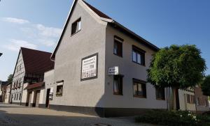 a building with a tree on the side of it at Gästezimmer & Ferienwohnungen Thon in Herbsleben +9 photos