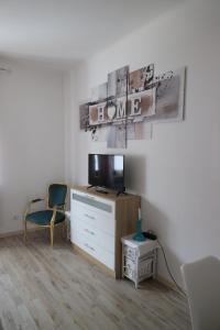 a living room with a tv and a chair at Apartment Viktoria in Püttlingen