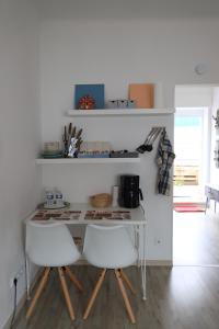 a kitchen with a white table and two white chairs at Apartment Viktoria in Püttlingen