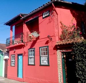 een rood huis met een blauwe deur bij Pousada Recanto de Minas - no Centro in Tiradentes