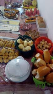een tafel met borden en kommen met voedsel bij Pousada Recanto de Minas - no Centro in Tiradentes