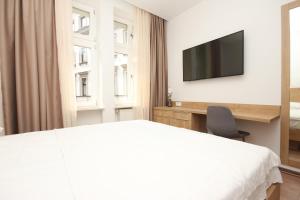 1 dormitorio con 1 cama y TV en la pared en Vila Alexandra en Sarajevo