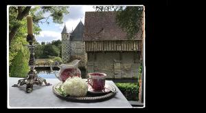 uma mesa com um vaso e um prato com flores em Manoir de Livet em Saint-Germain-de-Livet