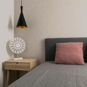 ティサケーチケにあるAranypart Apartmanházak Tiszakécskeのベッドルーム1室(ピンクの枕とランプ付きのベッド1台付)