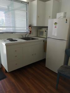 a kitchen with a white refrigerator and a sink at Tiki Village Inn in Vernon