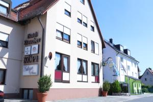 un bâtiment blanc avec des plantes devant lui dans l'établissement Hotel Daucher, à Nuremberg