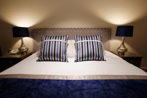 1 cama con 2 almohadas y 2 lámparas en Sandford Springs Hotel and Golf Club, en Kingsclere