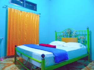 Aini Home Stay في تيرنيت: سرير في غرفة باللونين الأزرق والبرتقالي